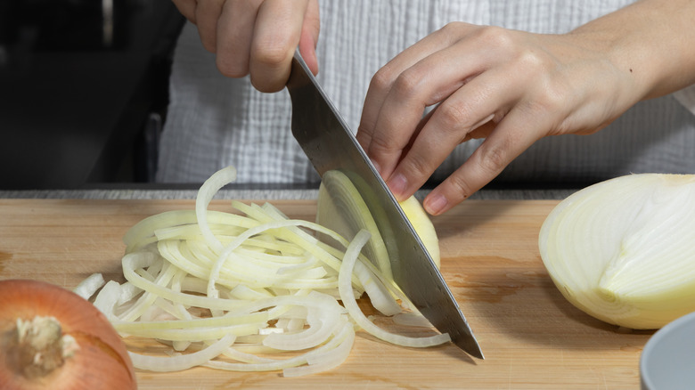 person slicing onions