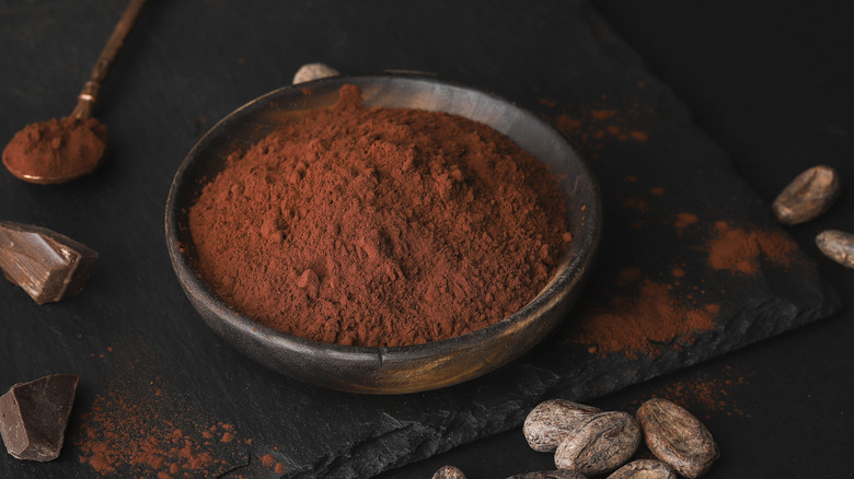 cocoa powder and chocolate chunks on dark stone tray