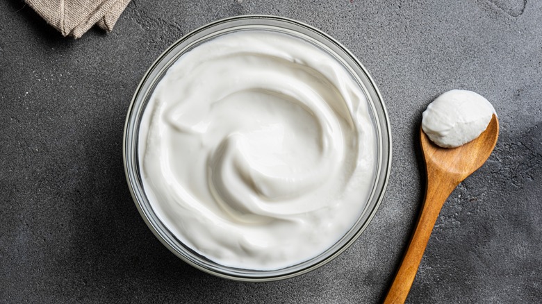 Bowl of yogurt next to wooden spoon