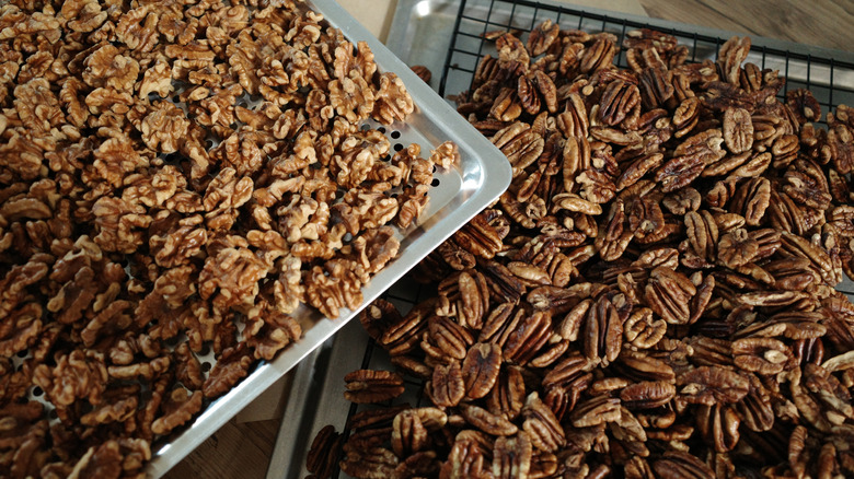 Oven-roasted walnuts and pecans on baking trays.
