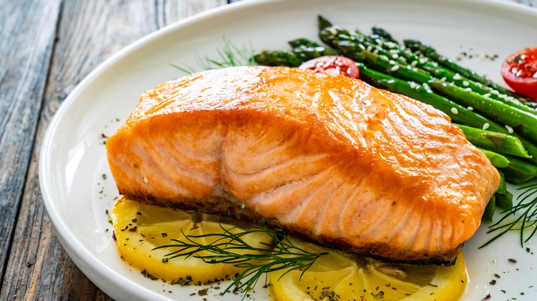 A fillet of salmon served with lemon slices.