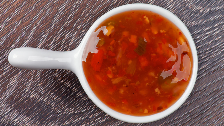 Sweet and sour sauce on a wooden background.