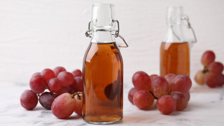 Bottled red wine vinegar and fresh grapes