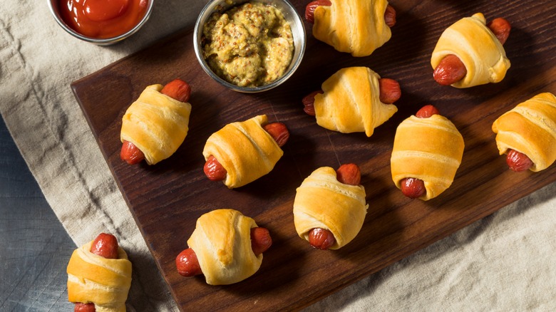 Pigs in a blanket on a wooden rectangular plate