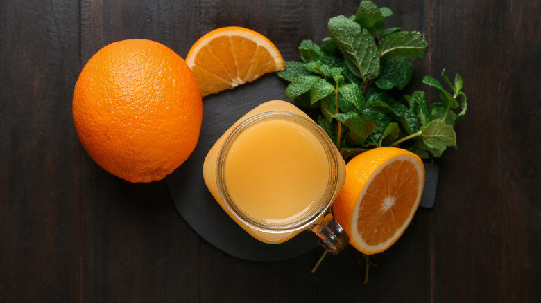 Mason jar surrounded by orange slices and mint