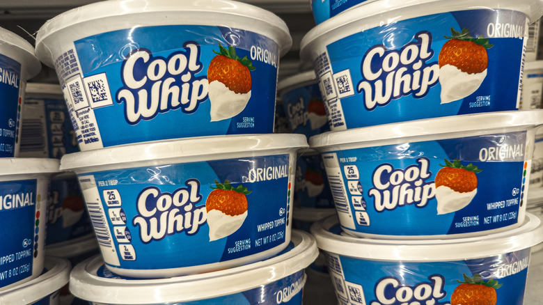 Tubs of Cool Whip stacked on a refrigerator shelf