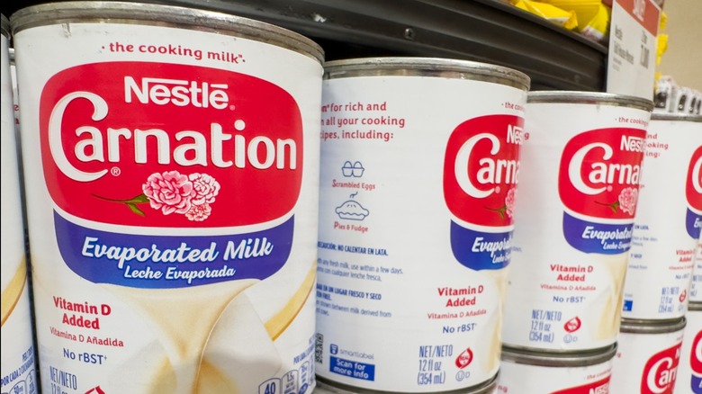 Cans of carnation evaporated milk stting on a store shelf