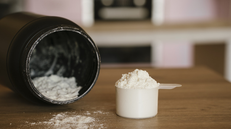 a scoop of collagen on a table next to its container