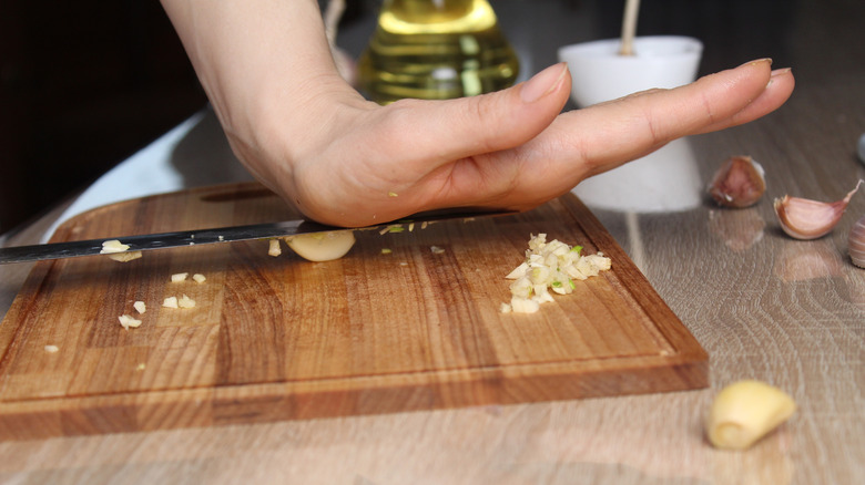 An individual crushing garlic.