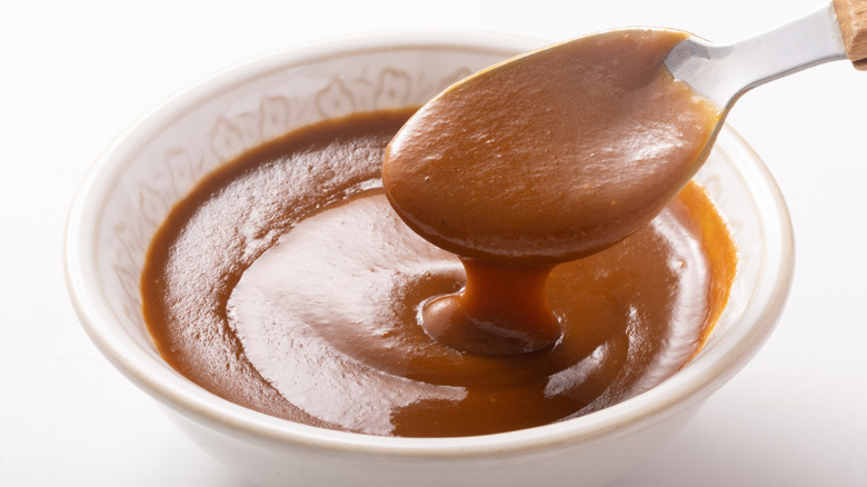 a bowl of demi-glace with a spoon