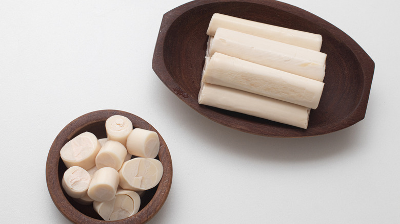 Whole and sliced heart of palm in wooden vessels