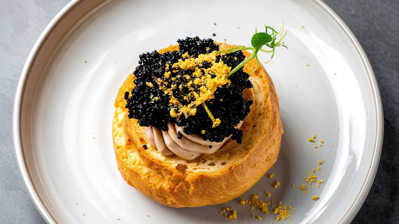 A crustini with a uni cream and caviar on top