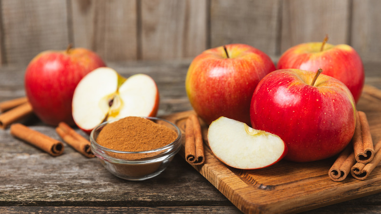 Various whole apples and slices with cinnamon