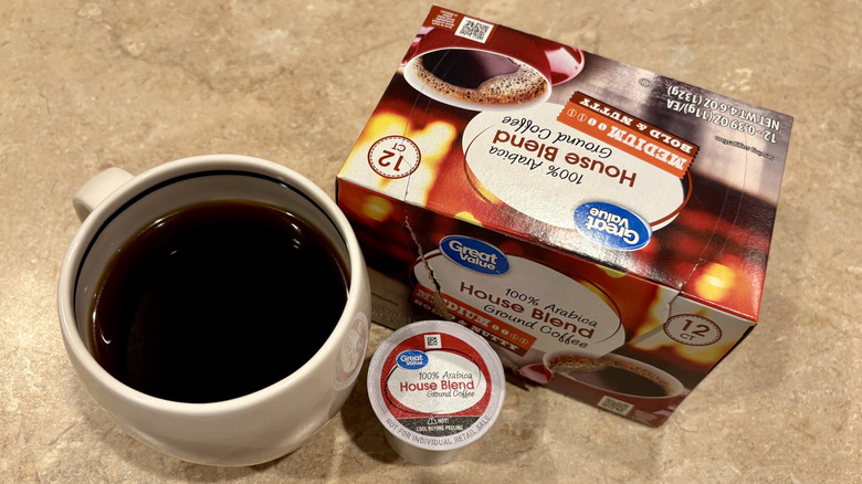 A mug of Great Value House Blend coffee next to its box and a pod