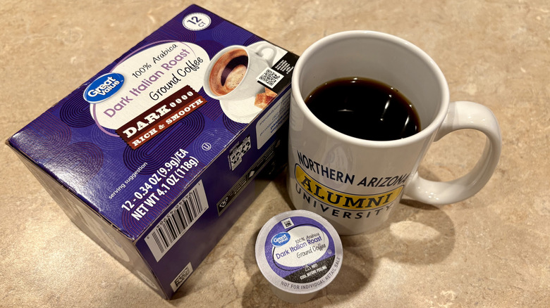 A mug of Great Value Italian Roast coffee next to its box and a pod