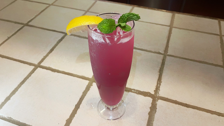 The Sicilian Sunset from Olive Garden on a white bar top with lemon and mint sprig garnishes