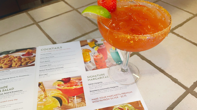 The strawberry limoncello margarita next to the cocktail menu at Olive Garden