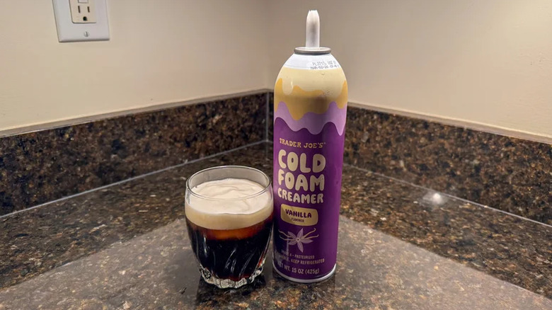 Trader Joe's cold foam creamer with glass of coffee