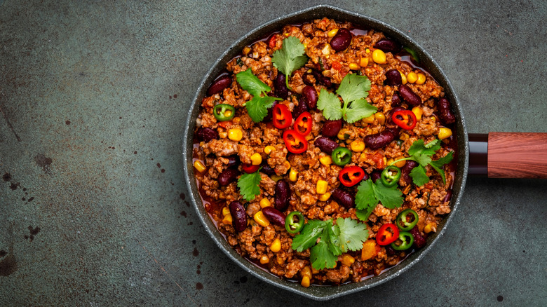 A bowl of chili with jalapeños