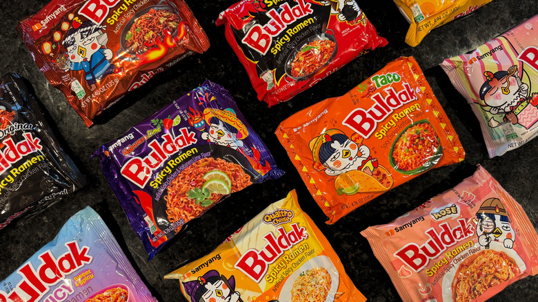 variety of packaged Buldak noodles on black countertop