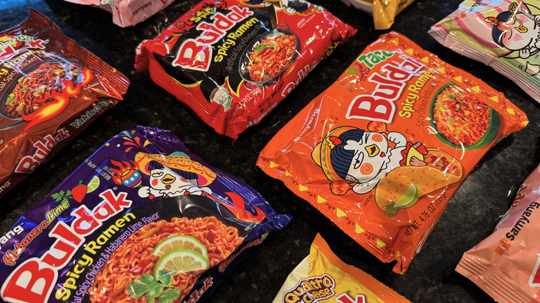 close-up of various packaged Buldak noodles on black countertop
