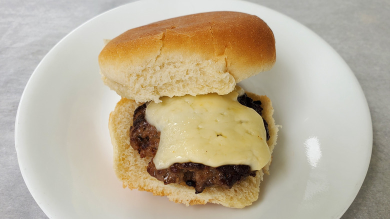 A beef slider with Havarti cheese on a white plate