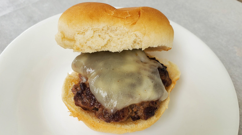 A beef slider with provolone on a white plate