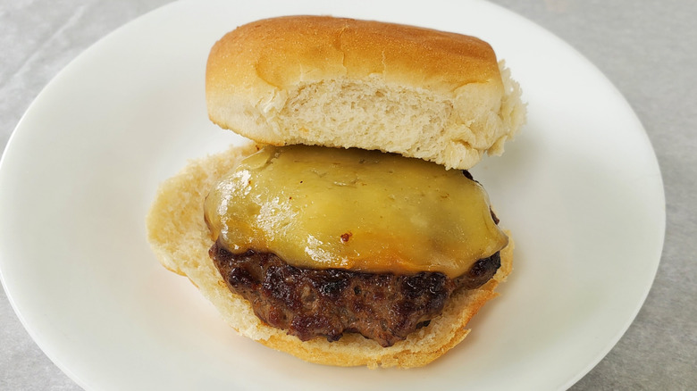 A beef slider with smoked Gouda on a white plate