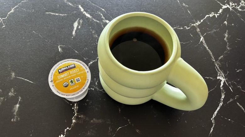 Kirkland summit roast coffee pod next to brewed cup of coffee
