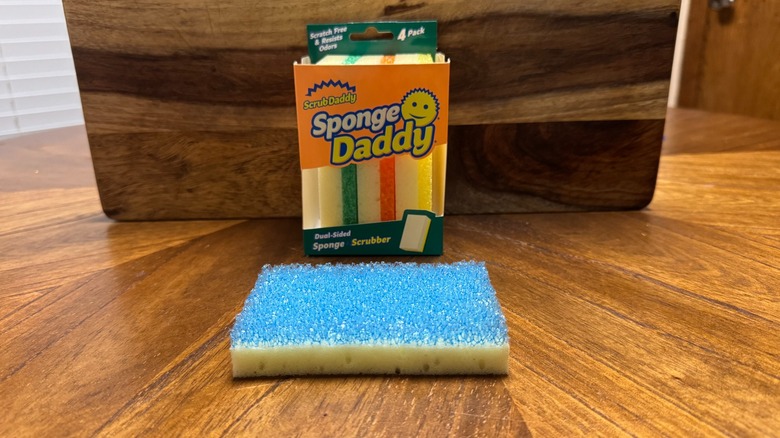 A package of Sponge Daddy sponges on a wooden background on a kitchen table