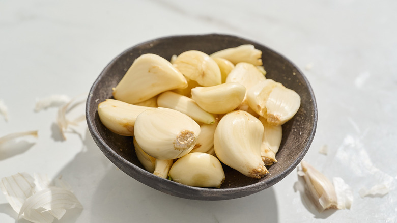 Bowl of peeled garlic cloves on a table