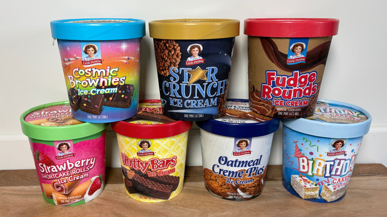 7 Little Debbie Ice Cream pints stacked on a wooden cutting board against a white background