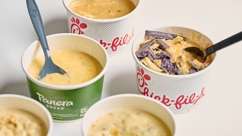 Soups and spoons in cups on a table