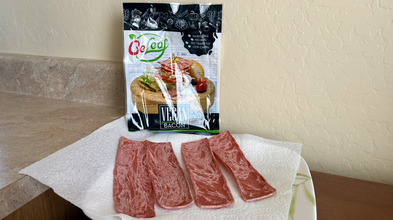 A plate of prepared Beleaf Vegan Bacon in front of its empty packaging