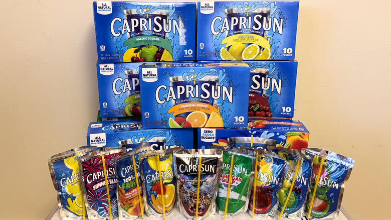 A display of various Capri Sun juice pouches in front of their box packaging