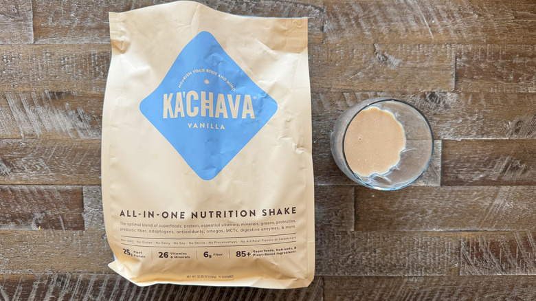 package and cup of Ka'Chava Vanilla Nutrition Shake mix on wooden surface