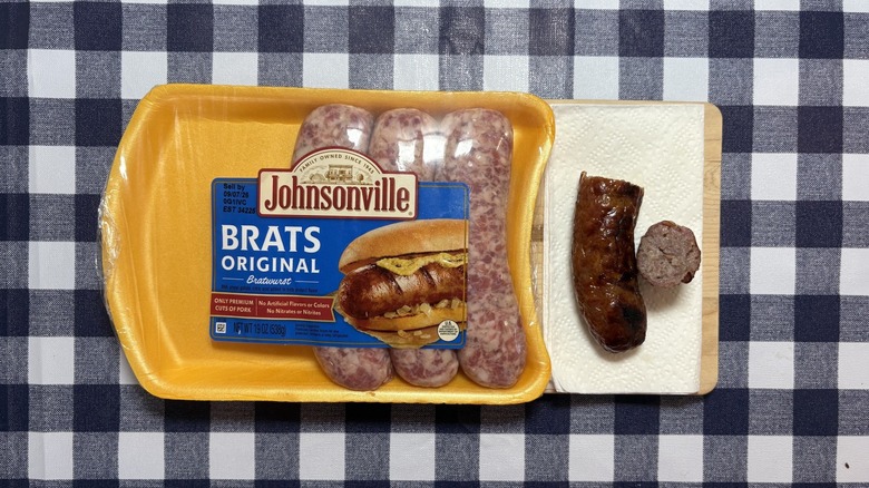 Johnsonville brat package next to cooked brat cut in half on checkered tablecloth