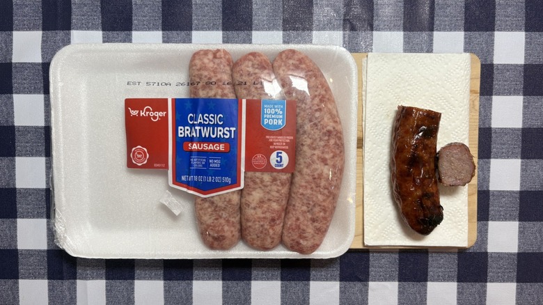 Kroger brat package next to cooked brat on checkered tablecloth