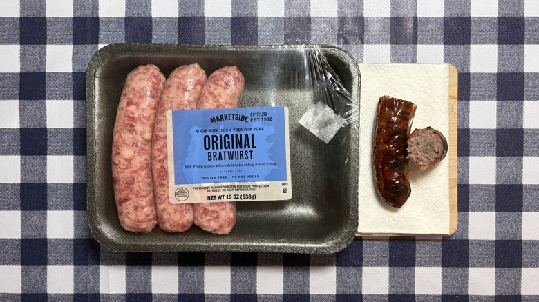 Walmart Marketside brat package next to cooked bratwurst on checkered tablecloth