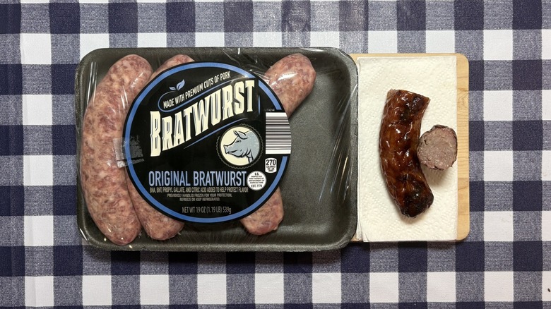 Aldi brat package next to cooked brat cut in half on checkered tablecloth