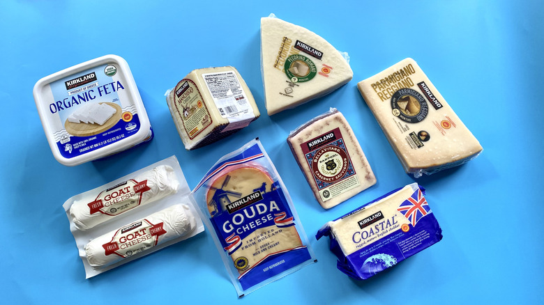 A collection of Kirkland Signature brand bulk cheeses on a blue surface