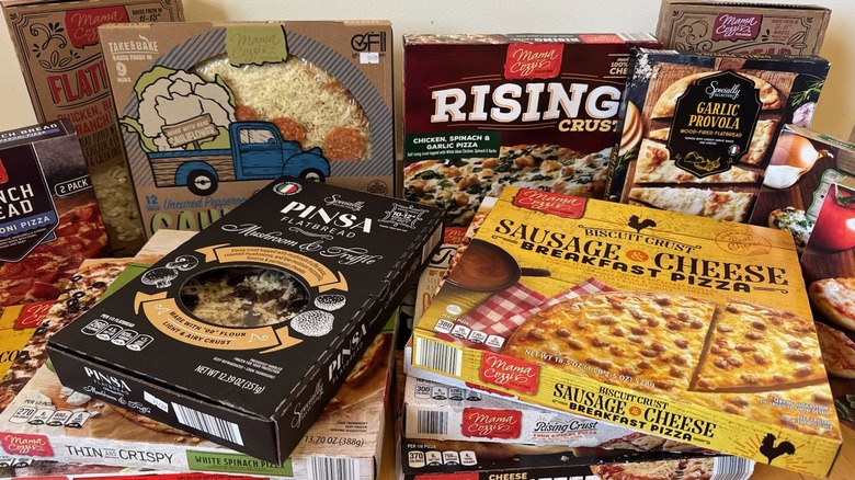 A variety of Aldi pizzas stacked on top of each other