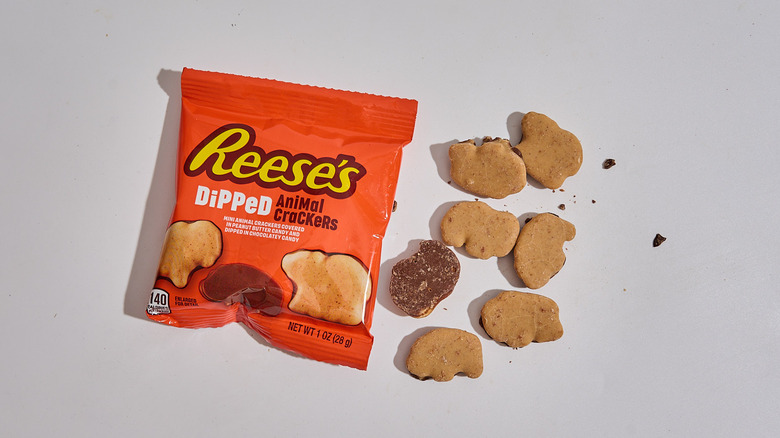 Package of Reese's Dipped Chocolatey Peanut Butter Animal Crackers on a table with a handful of animal crackers