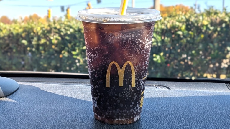 A McDonald's Diet Coke on a dashboard