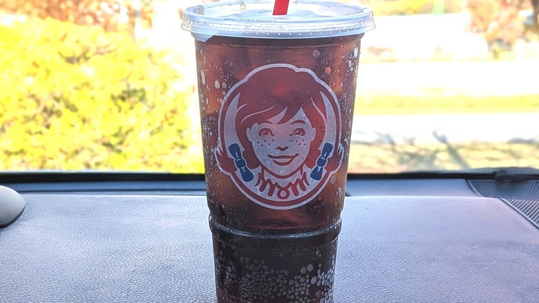 A Wendy's Diet Coke on a car dashboard