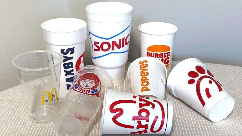 Eight fast food cups arranged on a table