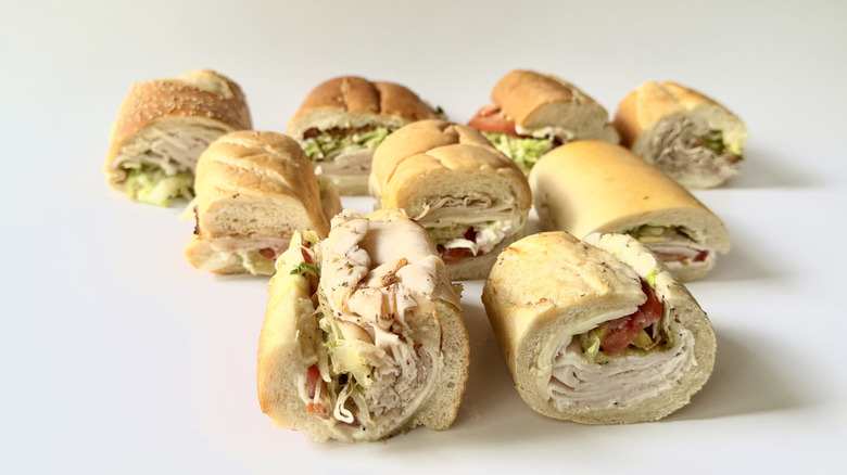 Rows of assorted turkey subs on a white background