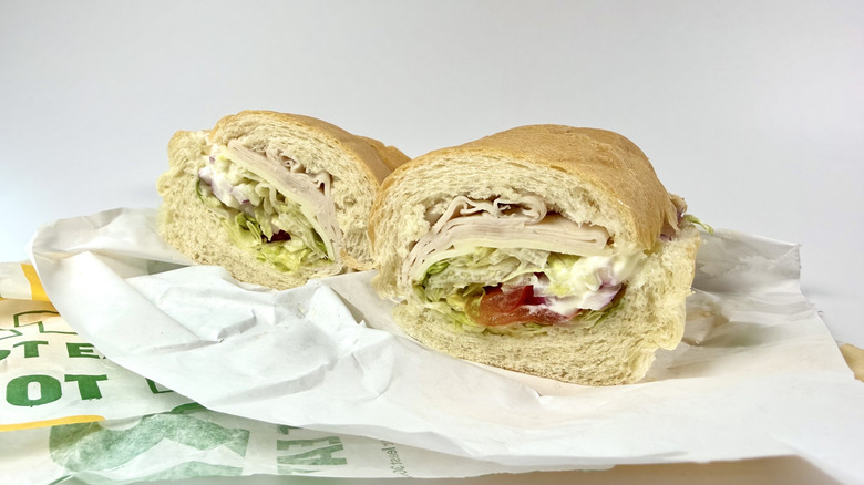 Subway's Oven-Roasted Turkey sub with its wrapping on a white background
