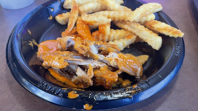 A plate of chicken bones and fries.