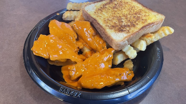 A plate of Buffalo wings, fries, and toast from Zaxby's.
